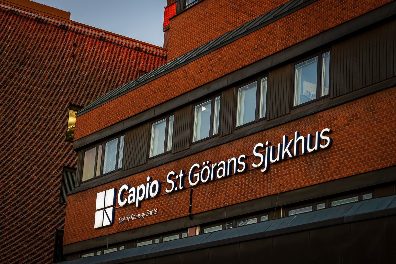 Bild på sjukhusets fasad i kvällsljus