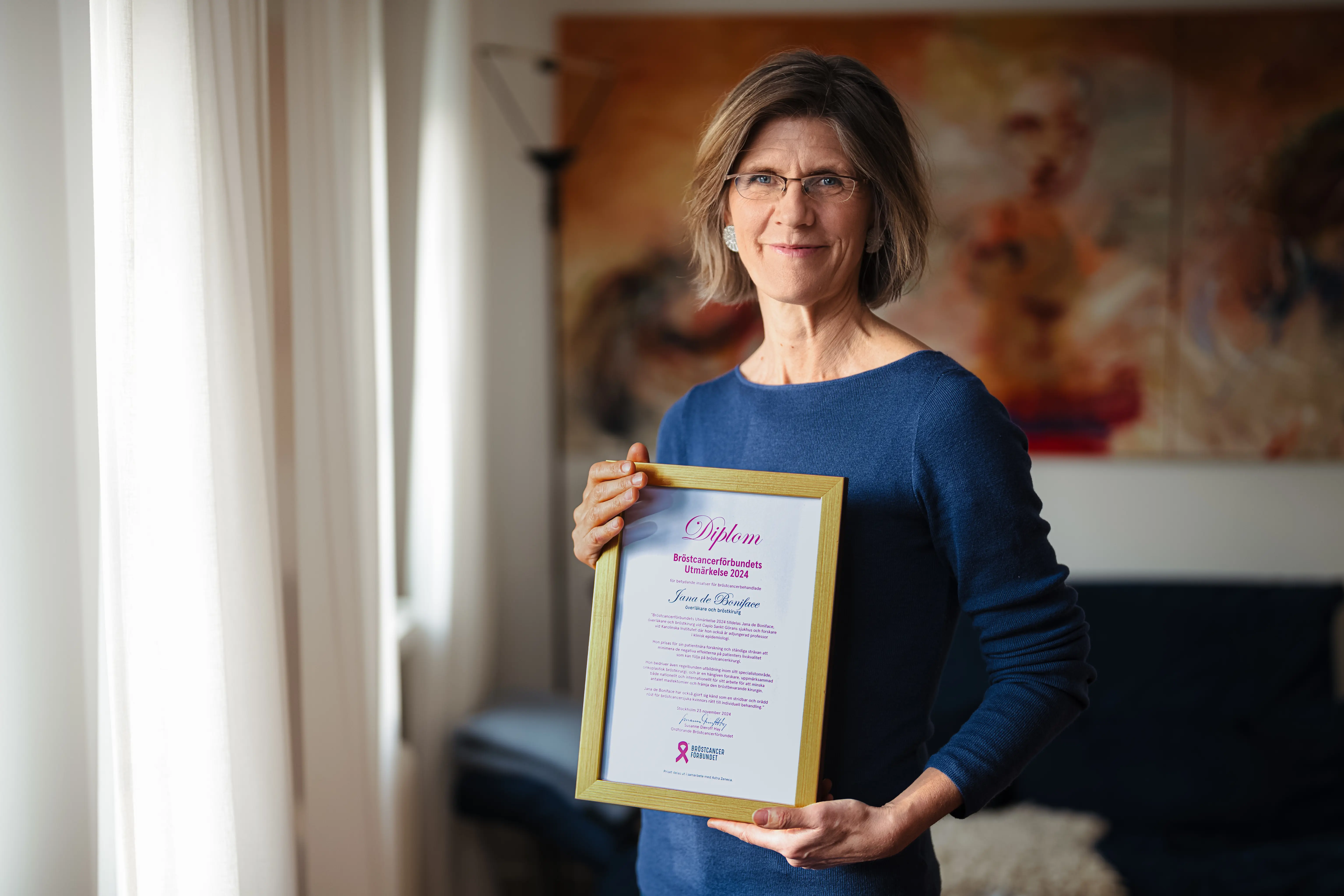 Jana de Boniface med diplom vid fönster.